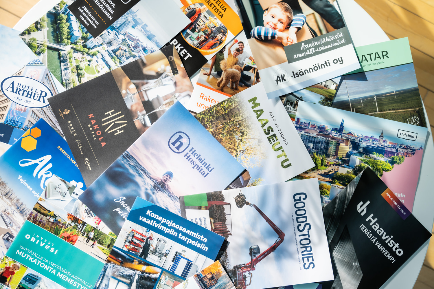 A table full of printed brochures from a variety of customers.